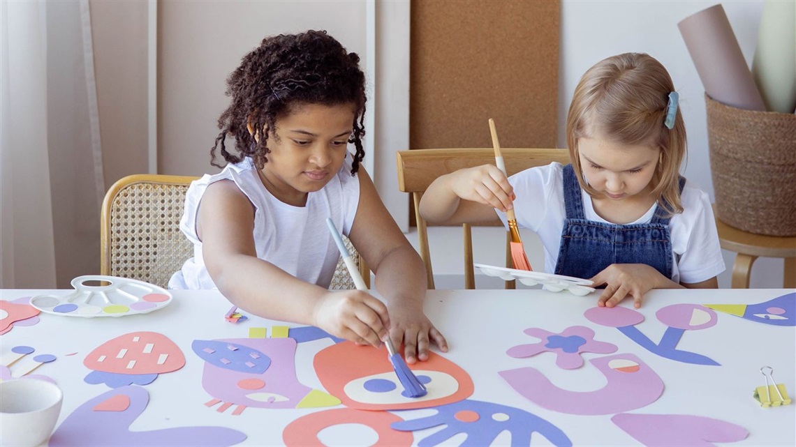 Two children painting at a table.
